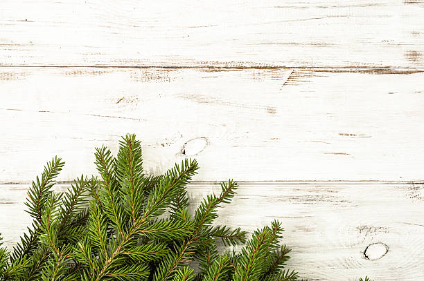 istock Christmas tree branch on wooden background useful as christmas decoration. 597639312
