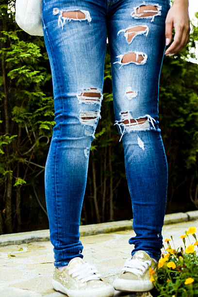 istock Women legs, jeans and sneakers 597640154