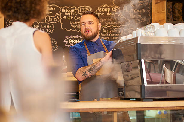 istock Smiling barista chatting to customer 597640264