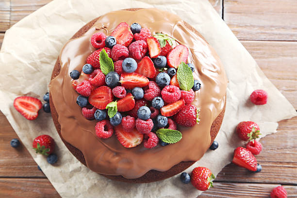 istock Homemade chocolate cake with berries on brown wooden table 597640666