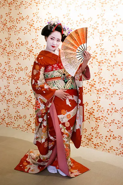 Maiko girl posing with Japanese folding fan