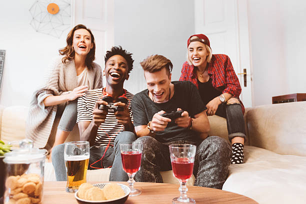 wielu etnicznych przyjaciół grających w gry wideo w domu - friendship video game young adult party zdjęcia i obrazy z banku zdjęć