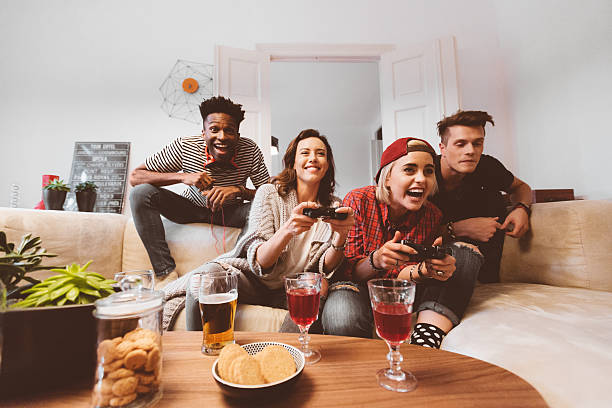 wielu etnicznych przyjaciół grających w gry wideo w domu - friendship video game young adult party zdjęcia i obrazy z banku zdjęć