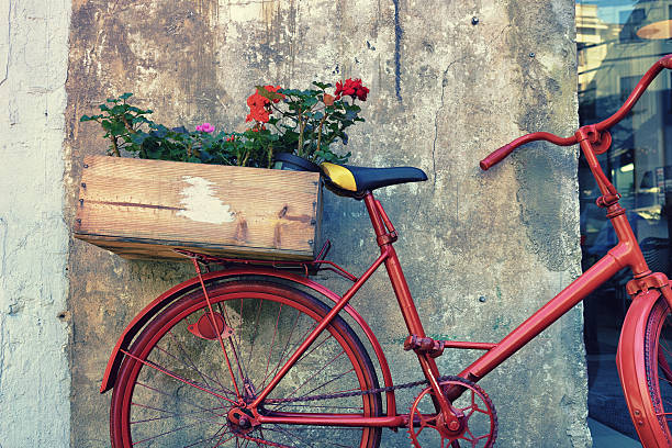 istock Flowers on a red bicycle near the wall 597643558