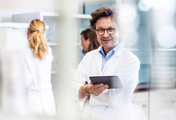 portrait of a male mid adult scientist in the laboratory - dna research forensic science healthcare and medicine imagens e fotografias de stock