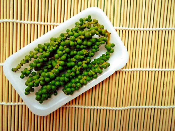 istock Fresh live green pepper on woven bamboo background 597648728