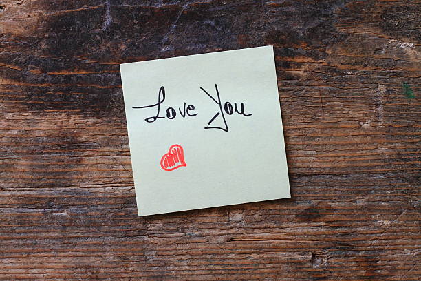 istock Message Love You with small red heart on wooden table 597651072