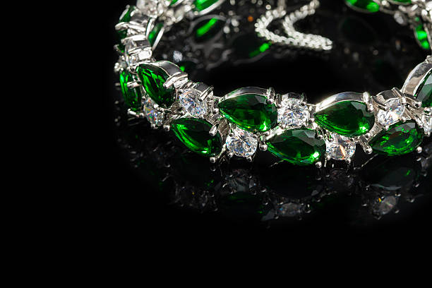 Bracelet with green stones isolated on black, close-up stock photo