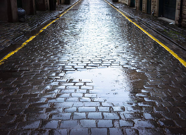 istock Puddle on a narrow cobbled street 597653194