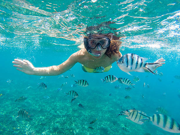 istock Young woman snorkeling 597653434