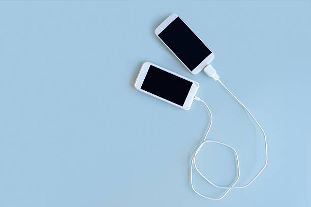 istock Two Smart Phones Connected Together by Cable 597654106