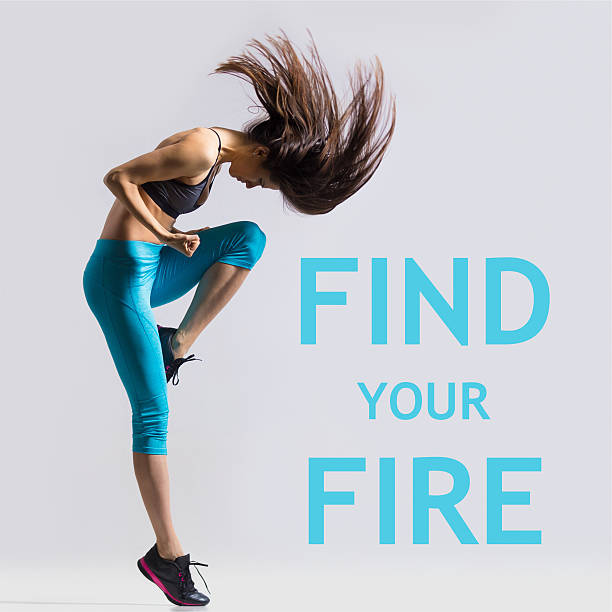 Find your fire Beautiful young fit modern dancer lady in blue sportswear warming up, working out, dancing with her long hair flying, full length, studio image on gray background. Motivational phrase "Find your fire" health motivation stock pictures, royalty-free photos & images