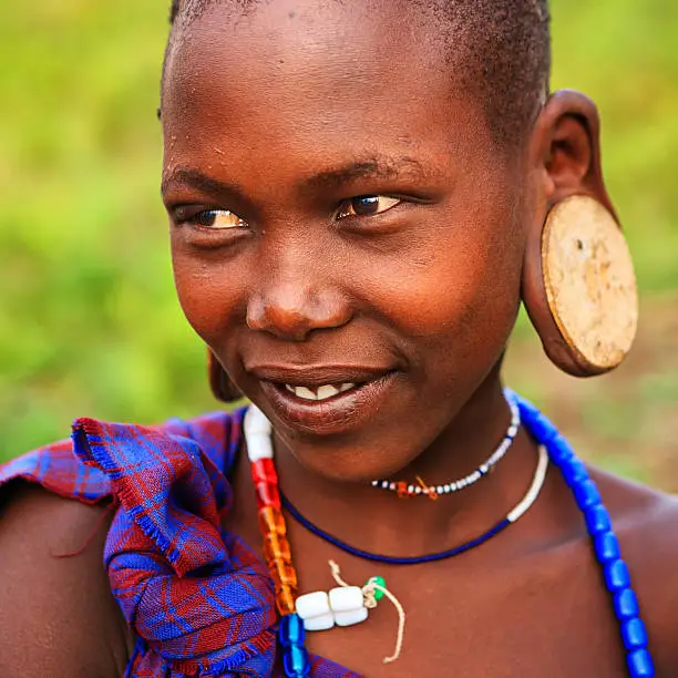 Young woman from Mursi tribe. Mursi tribe are probably the last groups in Africa amongst whom it is still the norm for women to wear large pottery or wooden discs or ‘plates’ in their lower lips.http://bhphoto.pl/IS/ethiopia_380.jpg