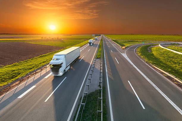 istock Delivery transport trucks on the empty highway at sunset 597657494