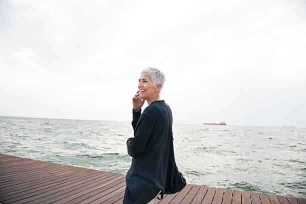 istock Smiling woman using mobile phone 597659274