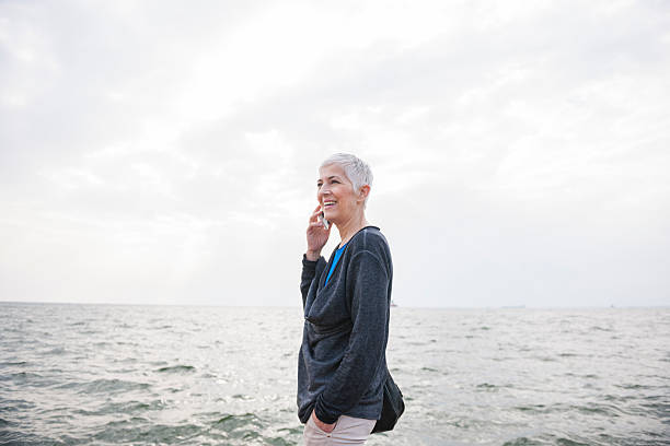 istock Smiling woman using mobile phone 597659396