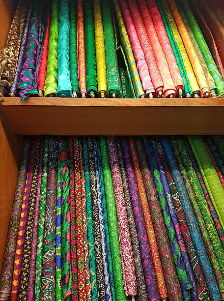 istock Stacks of vibrant textured fine silk cloth material rolls 597660772