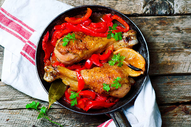 istock chicken drumsticks with a pepper in a frying pan. 597660792