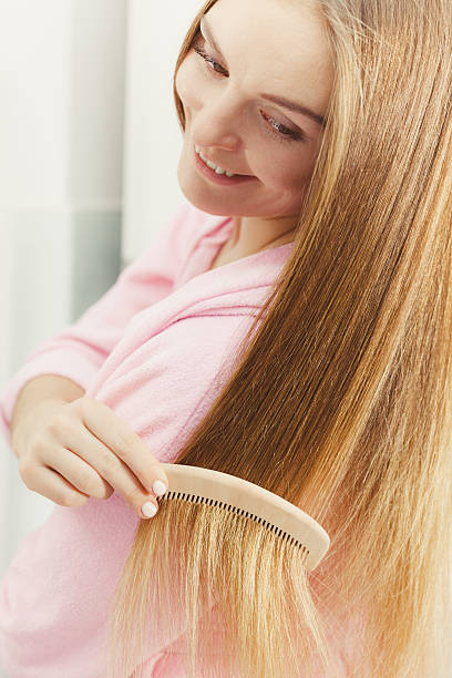 istock Woman combing her long hair in bathroom 597662806