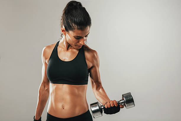 istock Attractive woman working out with dumbbells 597663440