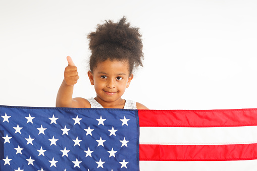 African American little girl showing thumb up. American flag on the front