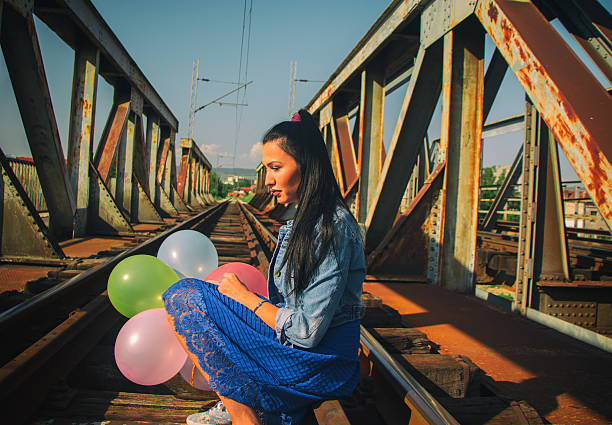 istock Young beautiful girl on railway bridge 597670412
