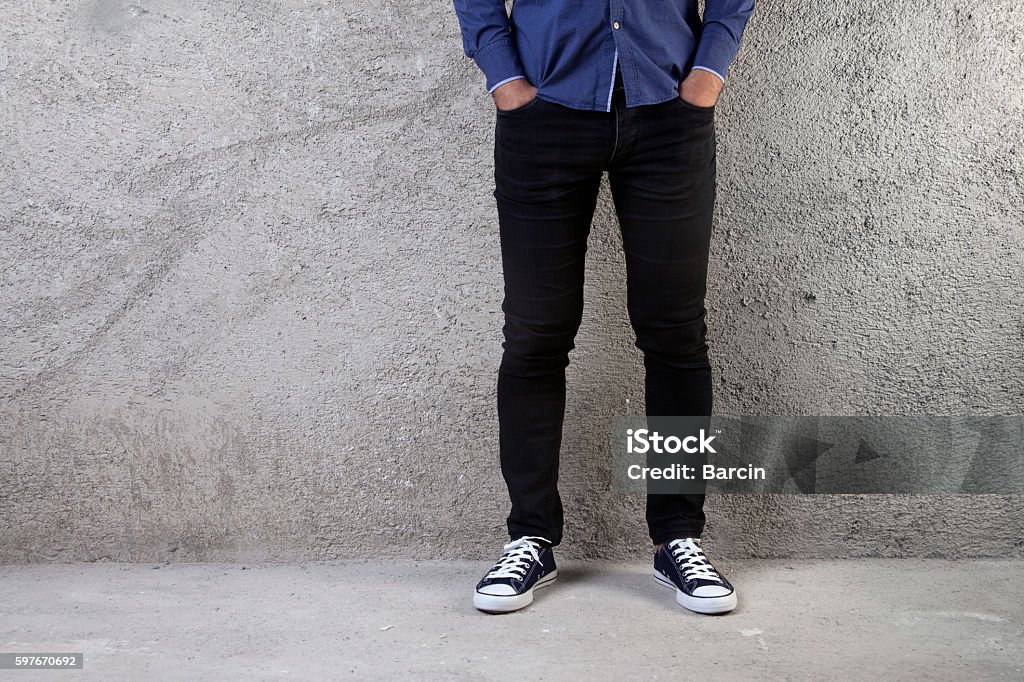 Young man standing on a concrete floor Black Color Stock Photo