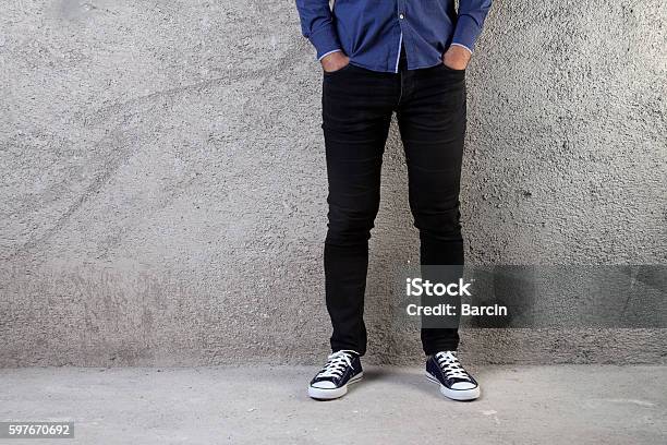 Young Man Standing On A Concrete Floor Stock Photo - Download Image Now - Black Color, Jeans, Men