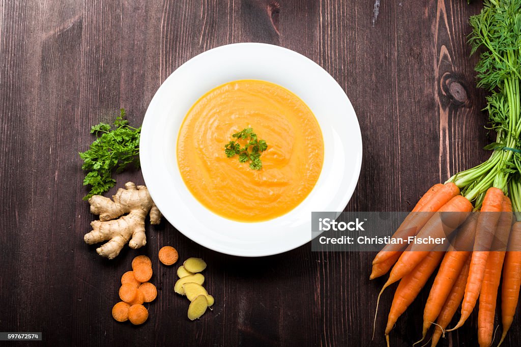 Carrot ginger soup Fresh carrot ginger soup with ingredients on background Carrot Stock Photo