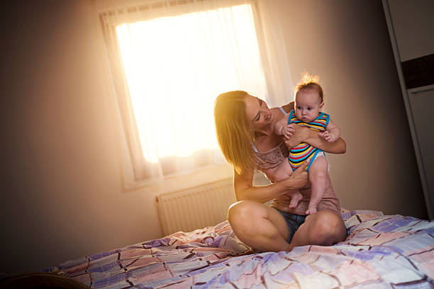 istock young mother holding her baby 597675786