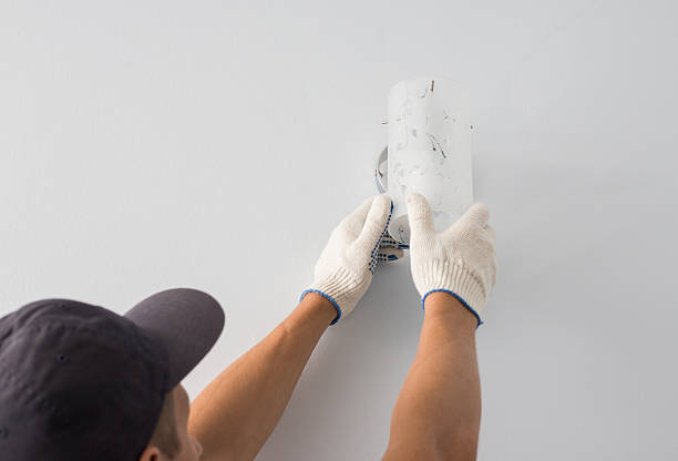 el hombre cambia una bombilla eléctrica, la eficiencia energética - sconce fotografías e imágenes de stock