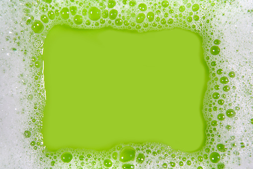 Frame made of soap sud with water in green tones. Much space for copy inside.