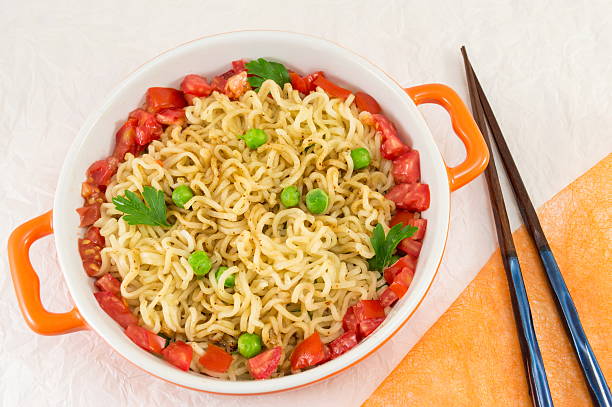 noodles with tomato and peas in a bowl