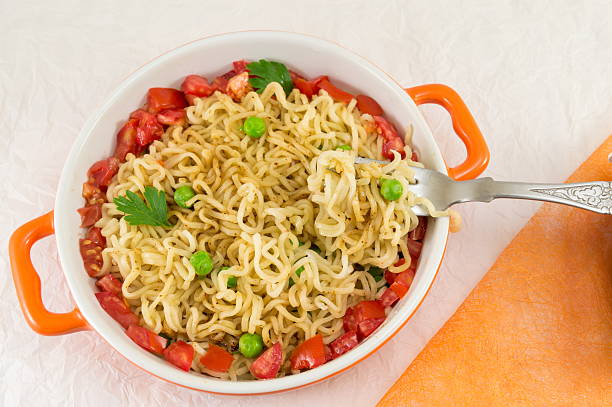 istock noodles with tomato and peas in a bowl 597928090