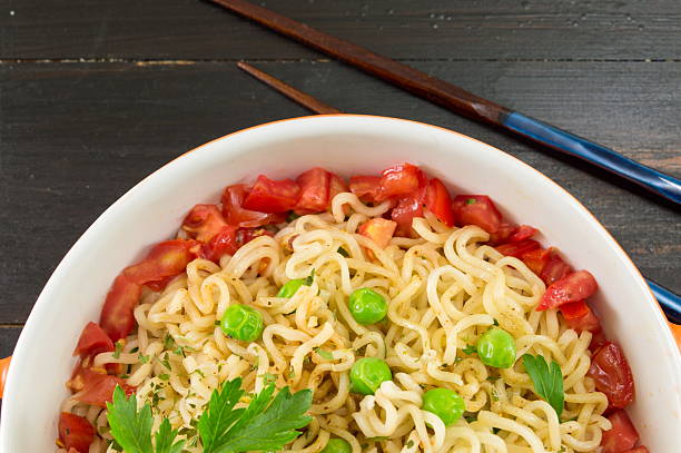 istock noodles with tomato and peas in a bowl 597928212