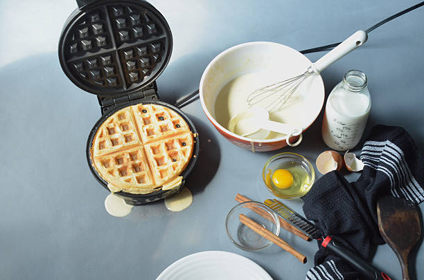 istock Waffle in open waffle iron, cinnamon grated from cinnamon sticks, 597930538