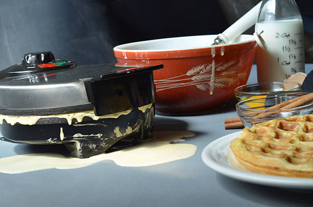 istock Waffle iron, cinnamon sticks, bowl of batter, utensils 597930664