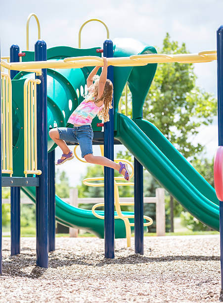 istock Girl Making Her Way Across Monkey Bars at Playground 597931192