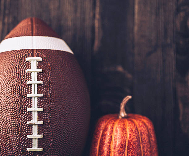 istock American football background with pumpkin 597931542