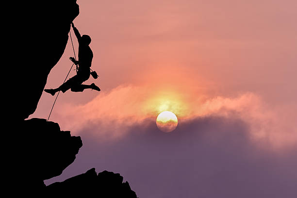 istock Rock climber silhouette over beautiful night sky 597932468