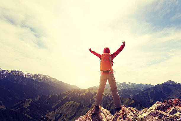 istock cheering successful woman backpacker open arms on mountain peak 597934288