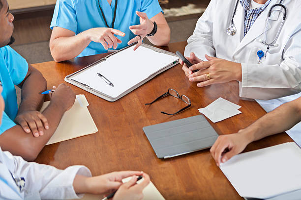 istock Busy hospital staff table during meeting in board room 597936280