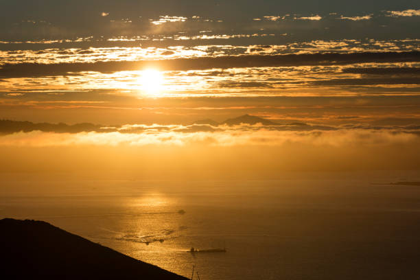 Early morning fog blankets the Background, sunrise red the sky.