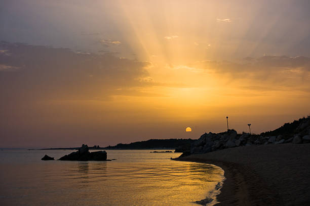 Sea rocks on a sandy beach at sunset, west coast of peninsula Sithonia, Chalkidiki, Greece
