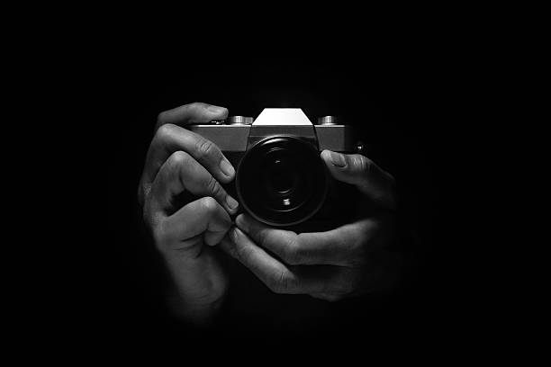 istock hand holding vintage retro style camera low key light 597938664