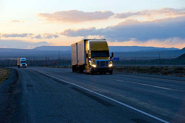 istock Semi trucks on highway in dark twilight evening 597941610
