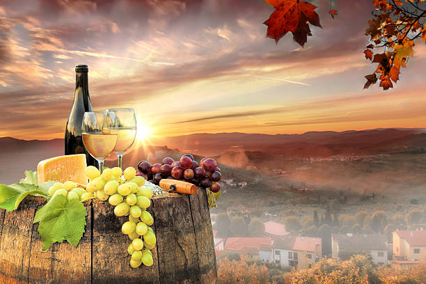 istock White wine with barrel on famous vineyard in Chianti, Italy 597946244