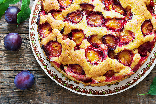 istock rustic plum cake on dark wooden background 597948276