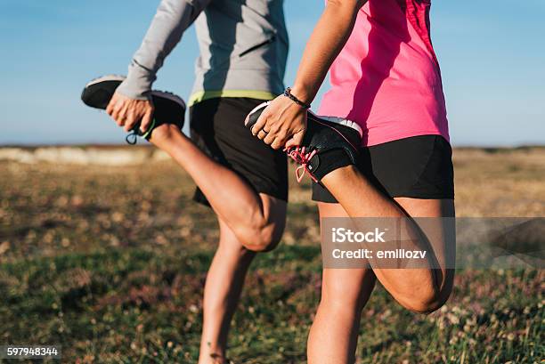 Sporty Couple Stretching Legs Outdoors Before Trail Running Workout Outdoors Stock Photo - Download Image Now