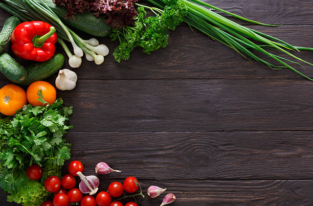 istock Border of fresh vegetables on wooden background with copy space 597948842